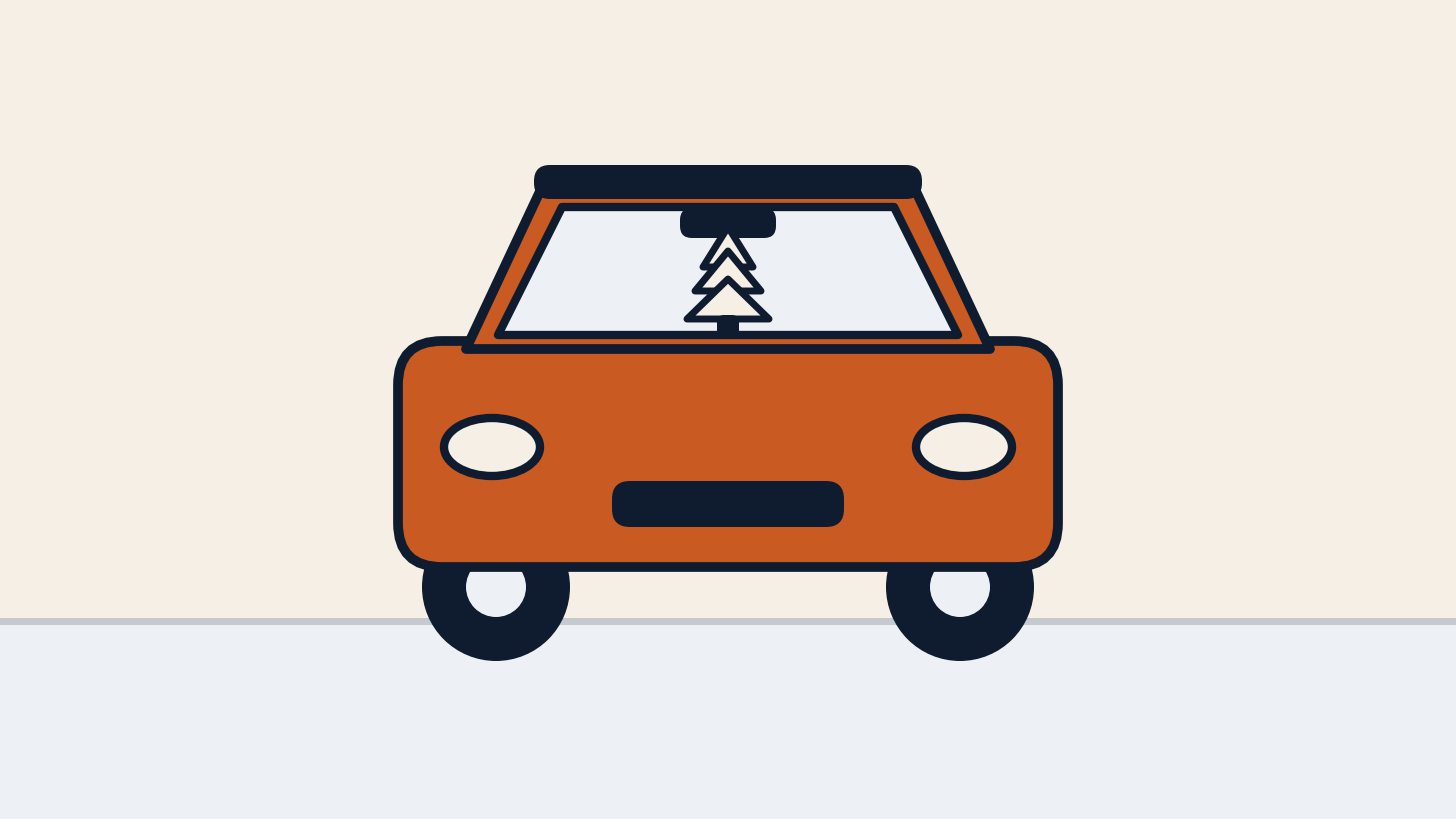 Front of a car with a small tree air freshener hanging from the rearview mirror